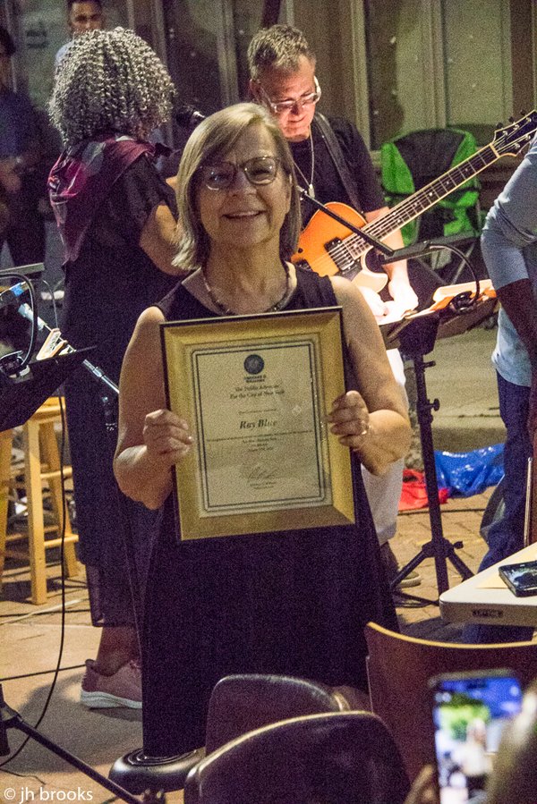 Riitta Blue holding the New York City Council proclamation honoring Ray Blue